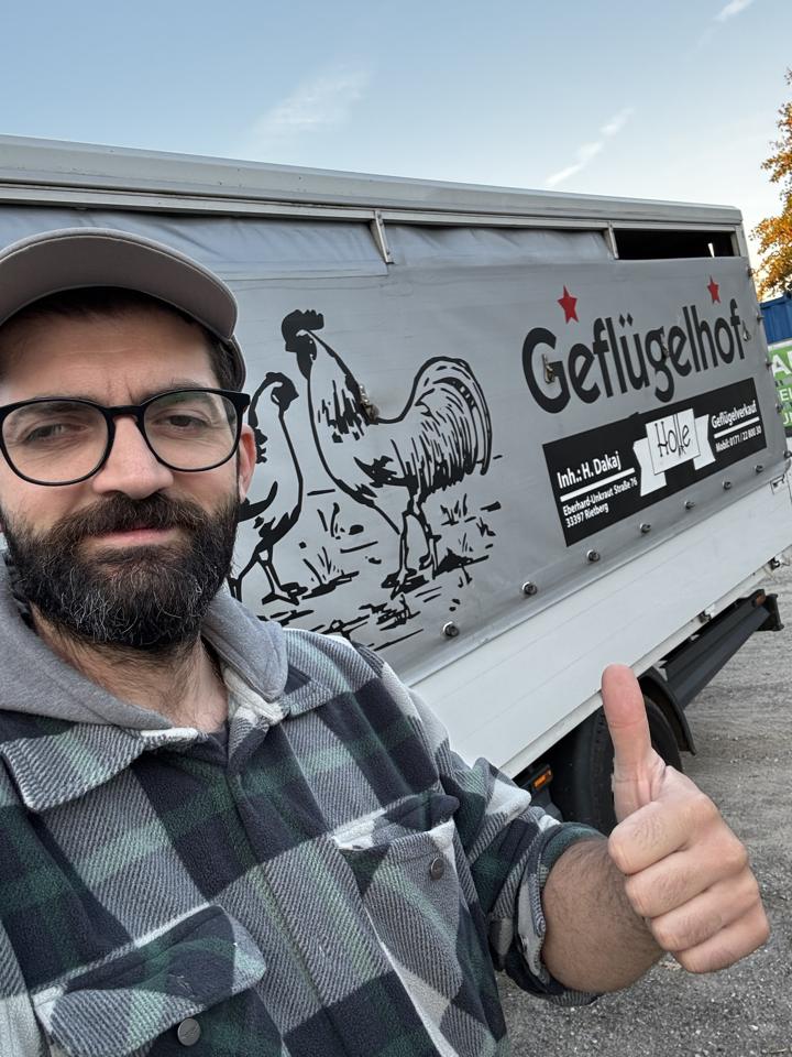 Mitarbeiter vor dem Verkaufswagen mit der Aufschrift Geflügelhof Holle, Daumen hoch